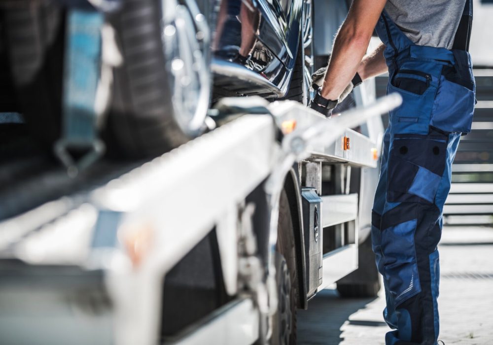 Professional Repo Worker Securing Car on a Towing Truck.